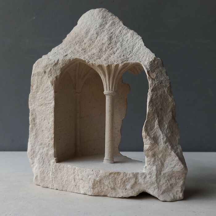 Artist carves a tiny architectural model of an ancient building into solid stone.