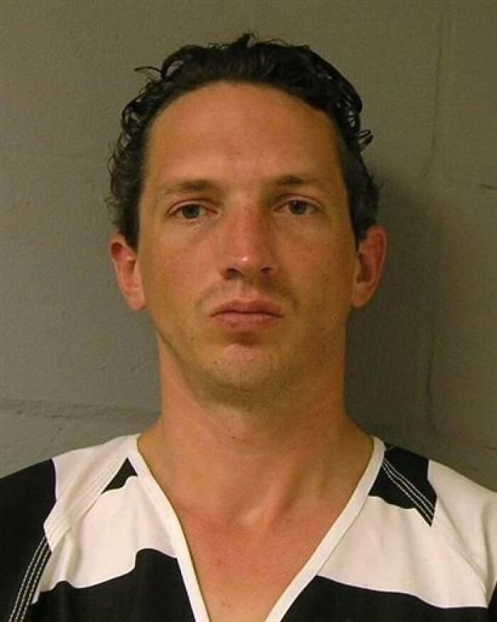Mugshot of a man in black and white striped prison attire