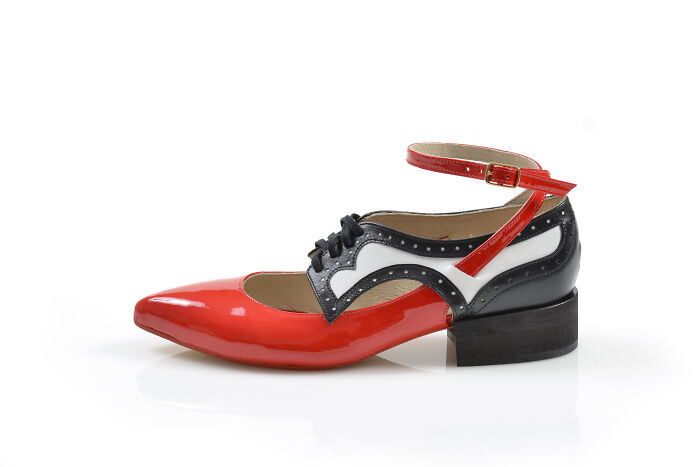A red, black, and white creative shoe design with an ankle strap and laces by Kobi Levi.