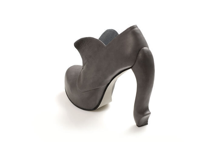 A single Kobi Levi creative shoe in grey, featuring a distinctive elephant trunk-like heel design.