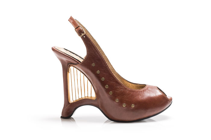 A Kobi Levi imaginative shoe in brown leather, designed with a harp-like structure integrated into the heel.