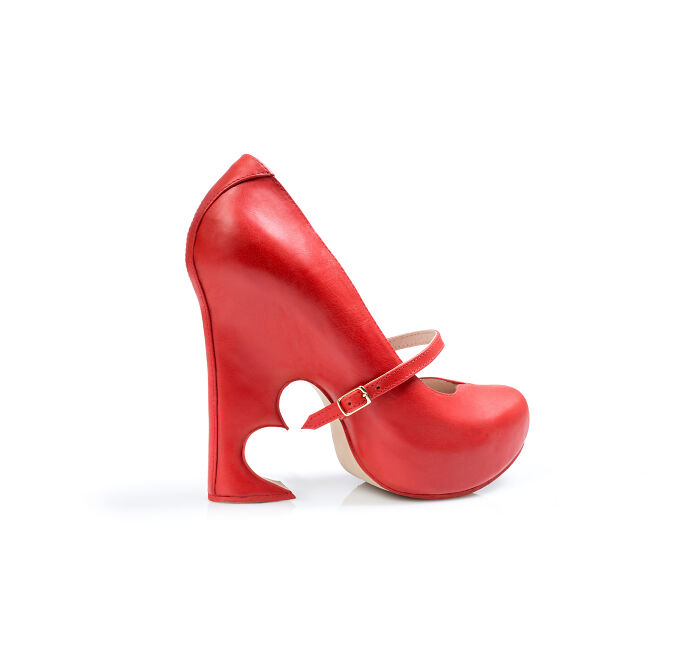 A red high-heeled shoe with a heart-shaped cutout on the heel by Kobi Levi, a creative shoe design.