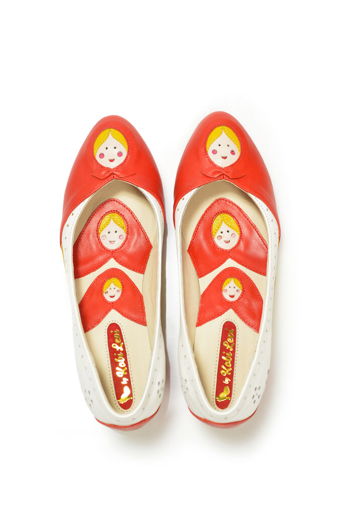 A pair of creative and imaginative shoes by Kobi Levi featuring a Russian nesting doll design on red and white flats.