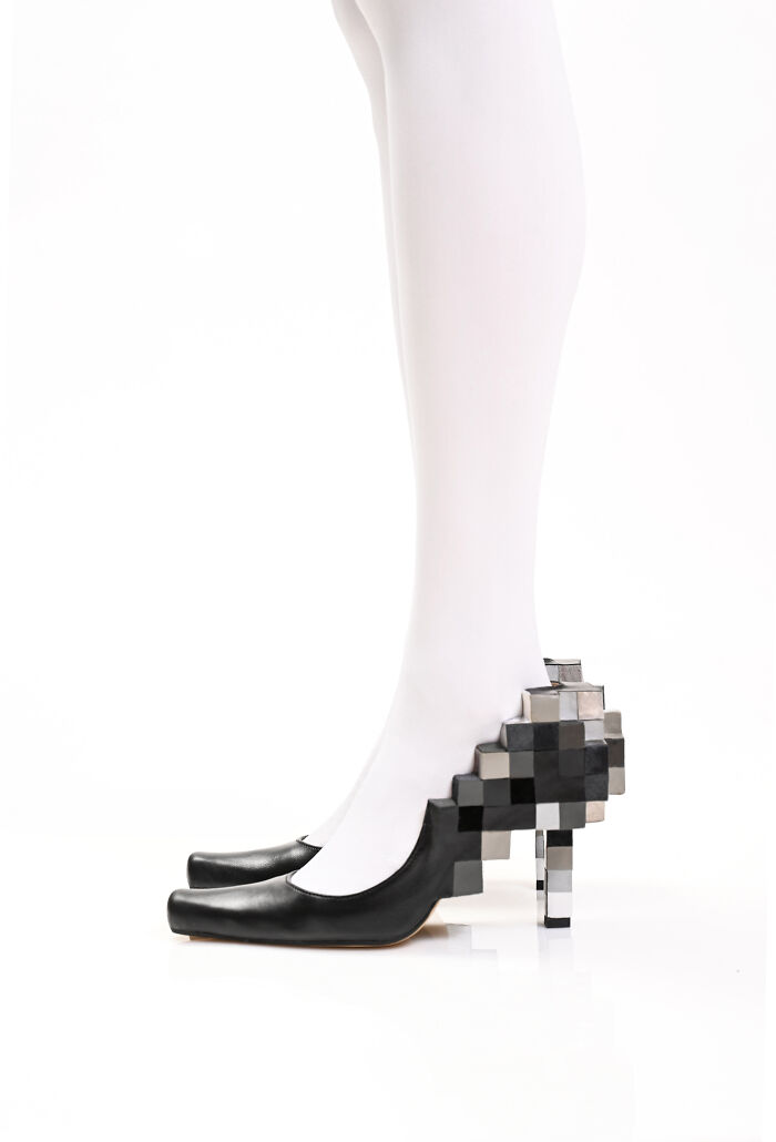 Creative and imaginative shoes by Kobi Levi, black heels with a pixelated block design on the heel, worn with white tights.