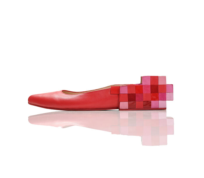 A creative and imaginative Kobi Levi shoe design, a red flat shoe with a pixelated red and pink block heel.