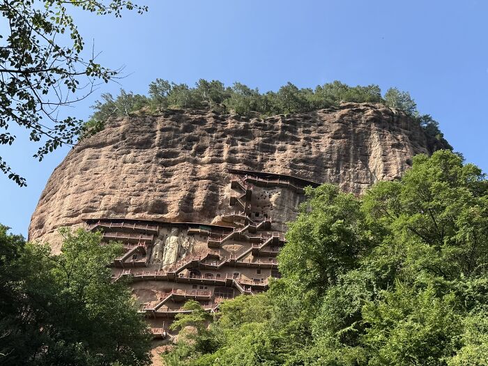 Massive mountain cliff with intricate wooden staircases carved into its face, a unique China travel experience.