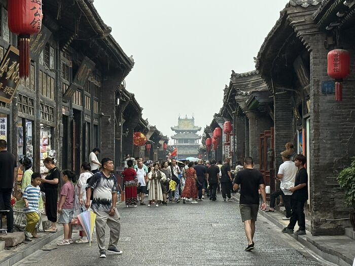 A bustling street scene in China with traditional architecture and many people, captured by a traveler.