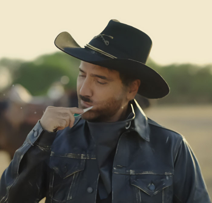 Man in cowboy hat brushing tongue symbolizing World Cup ceremony controversy