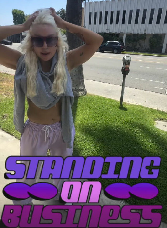 Amanda Bynes posing outside with light hair after 40lb weight loss standing on business text overlay