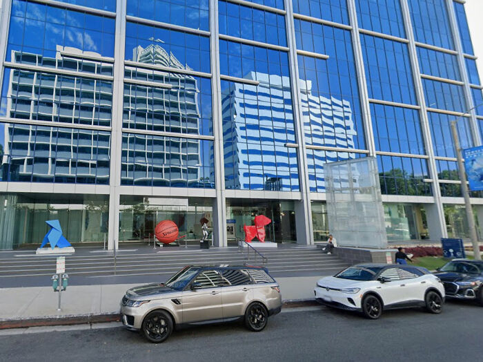 Building with reflective blue windows, hinting at a Hollywood voting scandal. Cars parked in front. Building with reflective blue windows, hinting at a Hollywood voting scandal. Cars parked in front.