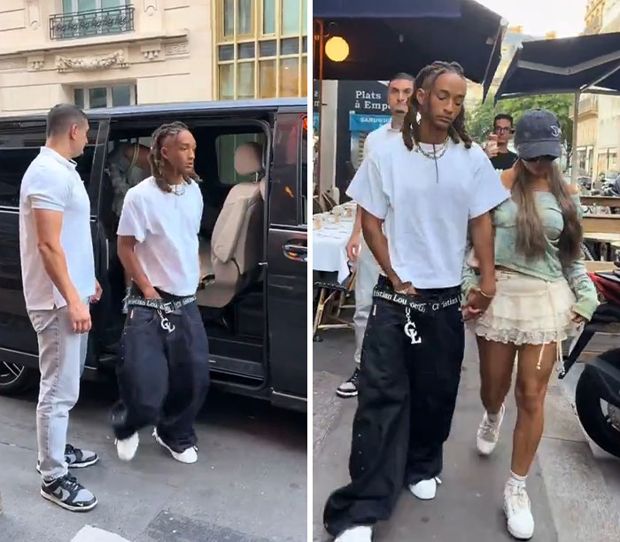 Jaden, Will Smith's son, in a white shirt and dark pants, stepping out of a car and walking with a companion.