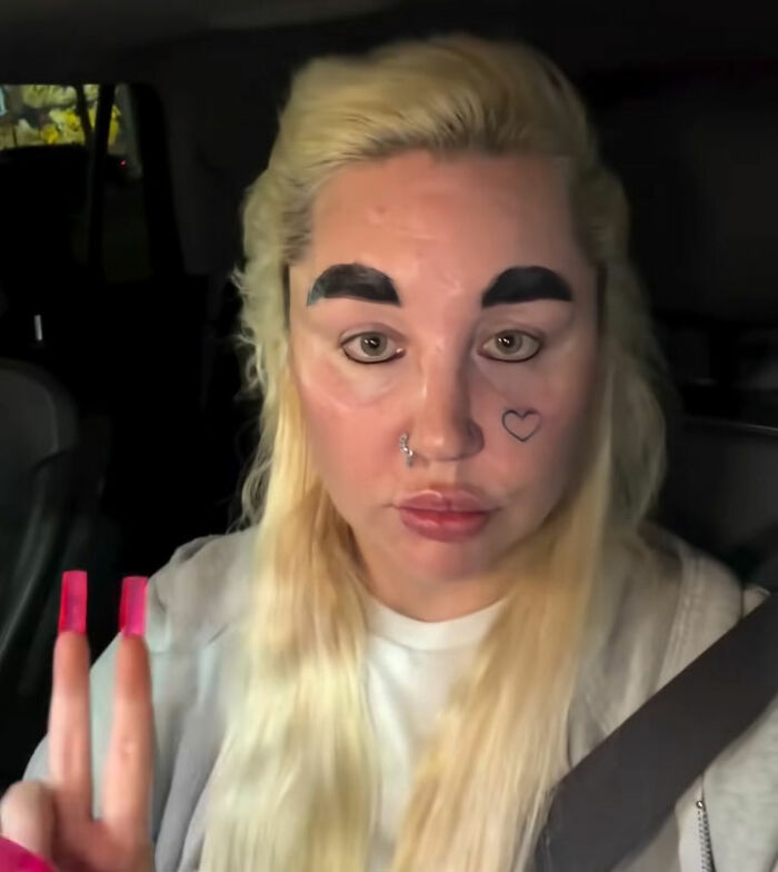 Amanda Bynes showing peace sign with bold eyebrows after weight loss