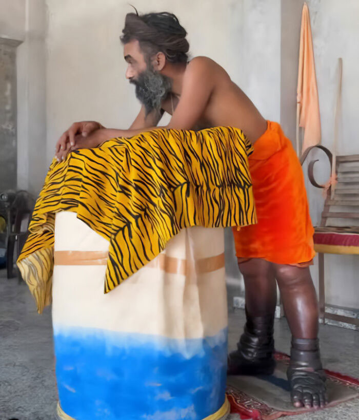 Man standing for over 5 years in an extreme act of devotion, leaning on a covered pillar. Man standing for over 5 years in an extreme act of devotion, leaning on a covered pillar.