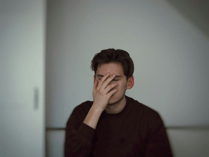 Stressed man covering face reflecting on mass walkouts