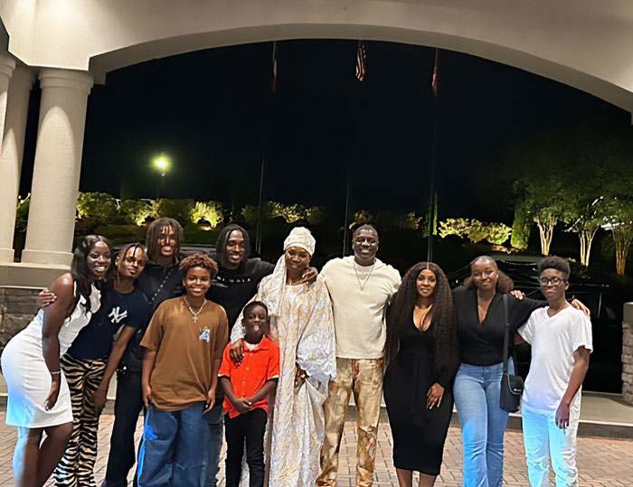 Group photo of Akon with family members outdoors at night