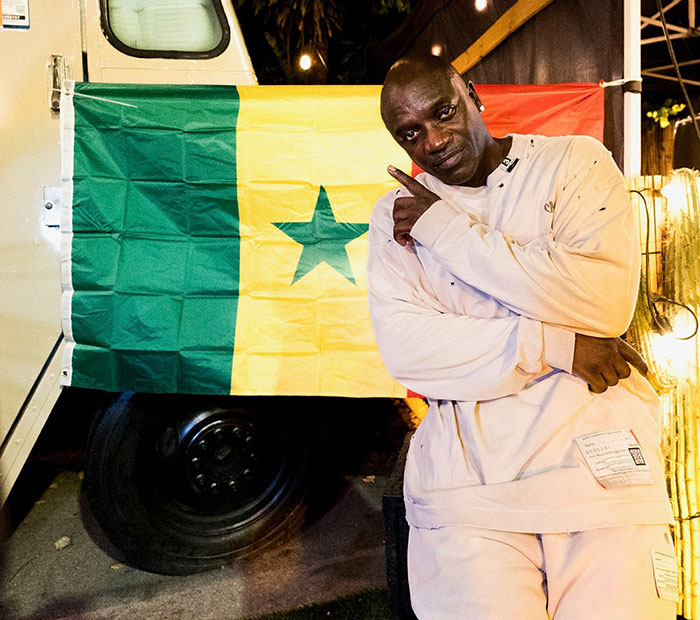 Akon posing in front of the Senegal flag representing his heritage