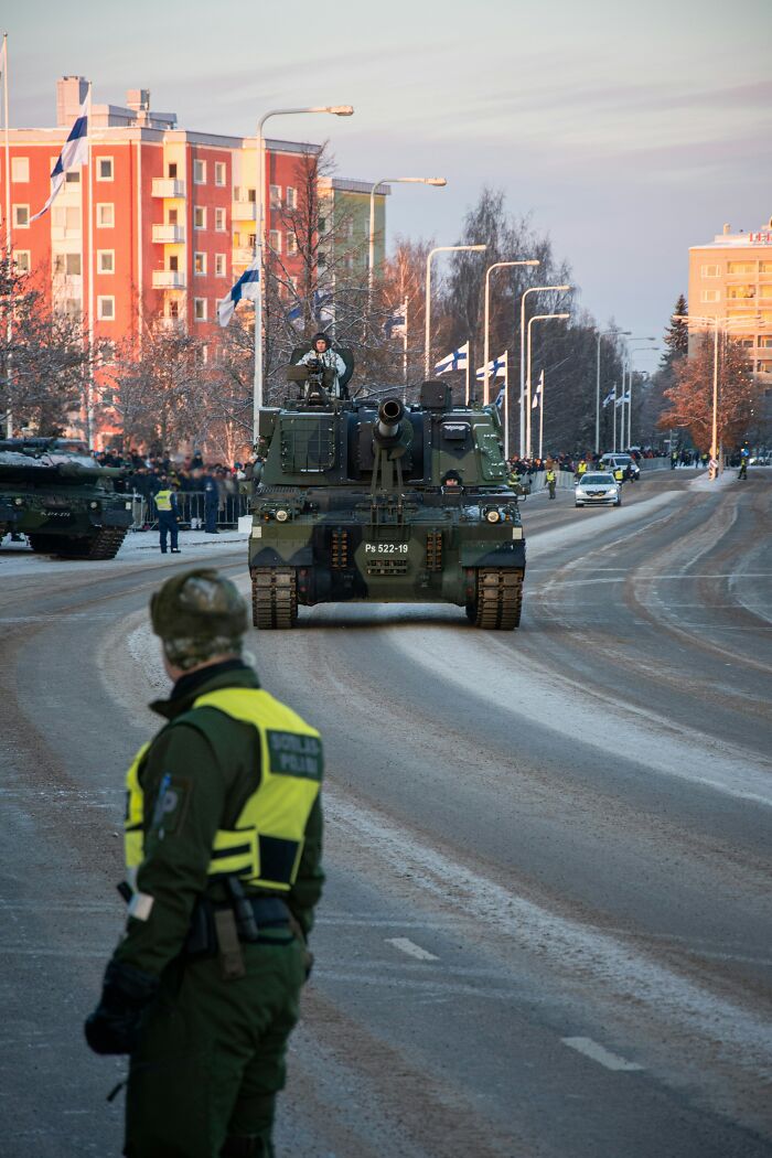 Military tanks parade on a snowy street, showing potential misunderstandings between locals and foreigners.
