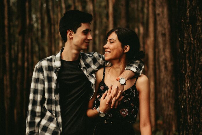 A happy young couple in a forest, looking at each other. Women decided to marry their partner.