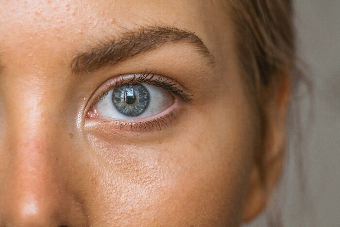 Close-up of a human eye showing detailed iris texture and skin near eyebrow