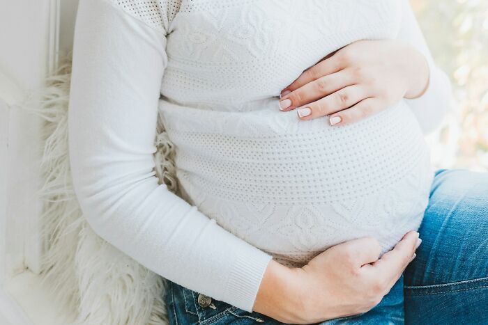 A pregnant woman cradling her belly, a serene image that could be contrasted with things found on her partners phone.