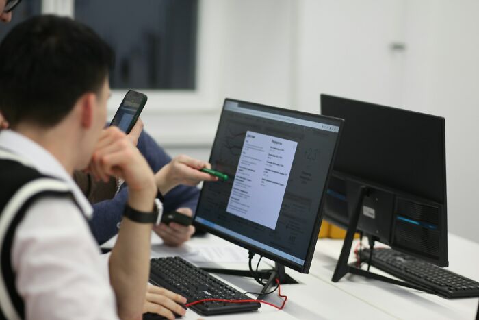 People using smartphones and computers in a tech workspace