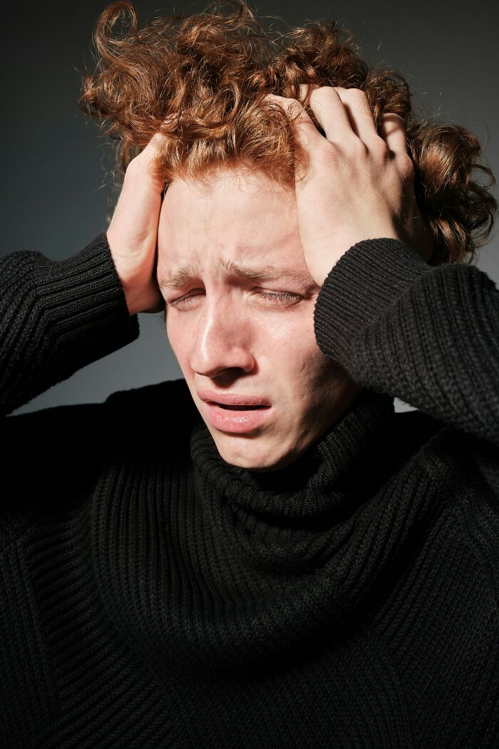 Stressed young man holding head with hands looking distressed