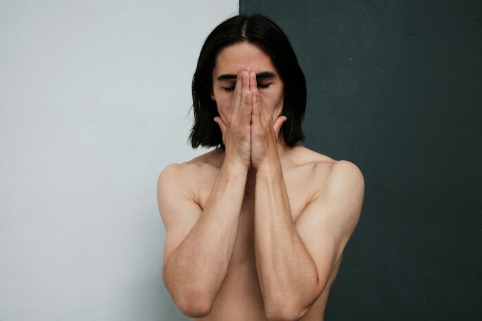 Man covering face with hands in a moment of self-care and satisfying reflection