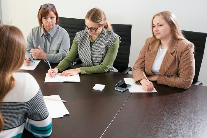 Three women interviewing a candidate around a table