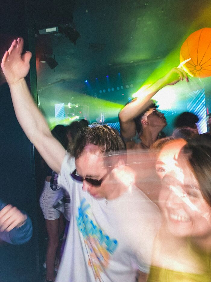 People dancing in a club with blurred motion, symbolizing a turning point when a marriage was over.