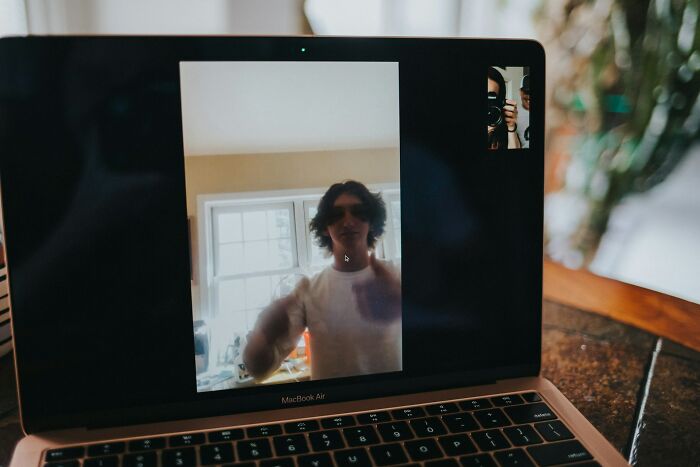 Video call on laptop screen showing person indoors