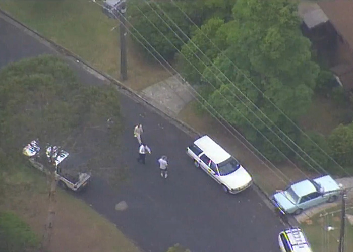 Aerial view of police investigation near parked cars on a suburban street