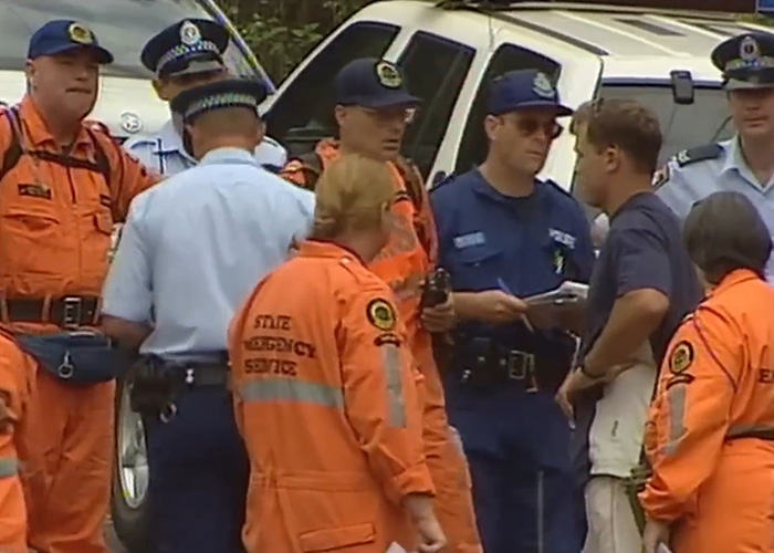 Police and emergency service personnel discussing at crime scene