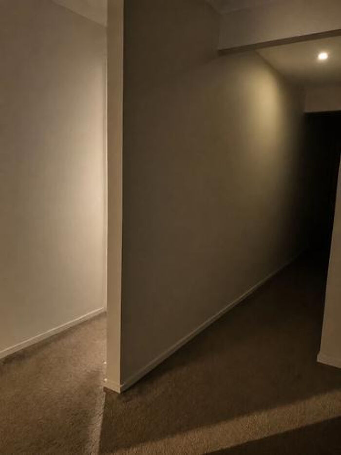 Dark, empty hallway with a single light, creating an unsettling liminal space.