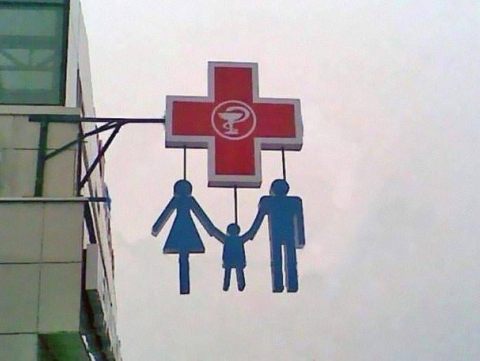 Pharmacy sign featuring a family design with confusing adult symbols causing design fail
