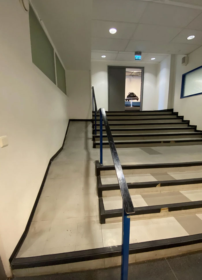Awful design fail shows inaccessible ramp next to stairs without safety handrails