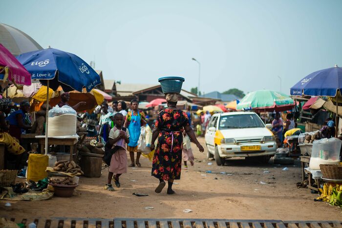 Busy outdoor market scene showing local vendors and shoppers in a developing country
