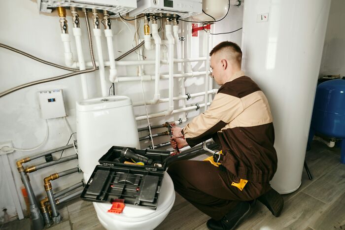 Plumber repairing pipes highlighting American home plumbing services