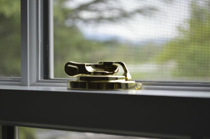 Window latch close-up with screen showing American home luxury