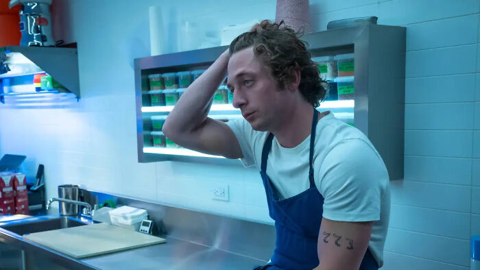 Carmy from The Bear looking stressed in the kitchen, reflecting the backlash and insufferable character.