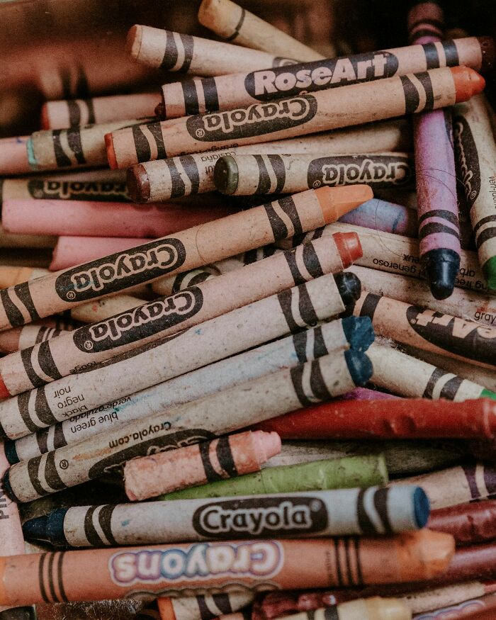 Close-up of used Crayola crayons in various colors scattered