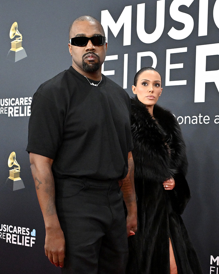 Kanye and Bianca Censori at a MusiCares Relief event, Kanye wearing sunglasses and a black outfit, Bianca in a fur coat. Kanye and Bianca Censori at a MusiCares Relief event, Kanye wearing sunglasses and a black outfit, Bianca in a fur coat.