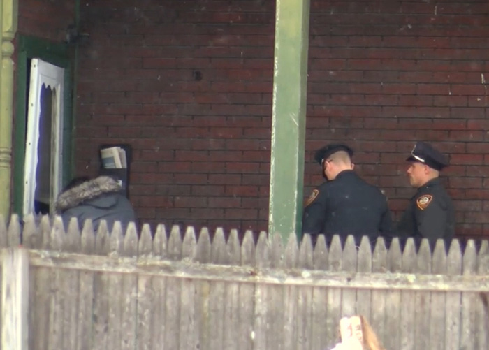 Police officers at a home, investigating the motives after a biker found a baby crawling out at night.