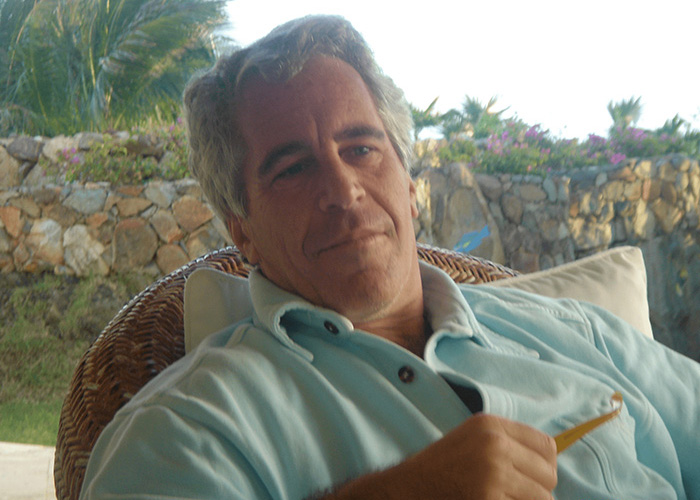 Jeffrey Epstein sitting outdoors with a relaxed expression Jeffrey Epstein sitting outdoors with a relaxed expression