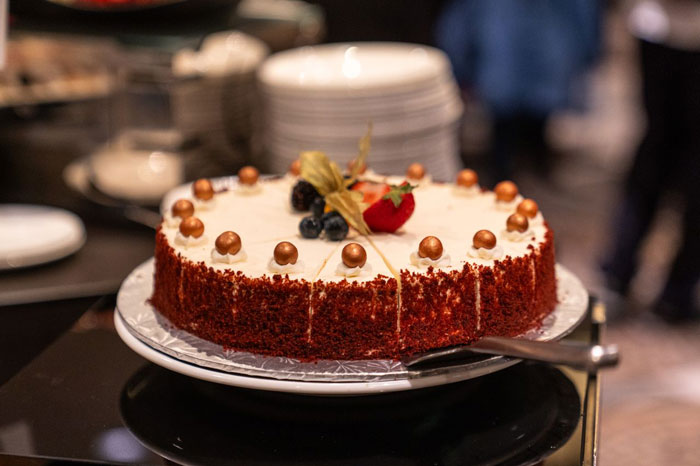 Close-up of a decorated birthday cake with fruit and chocolate balls on a plate