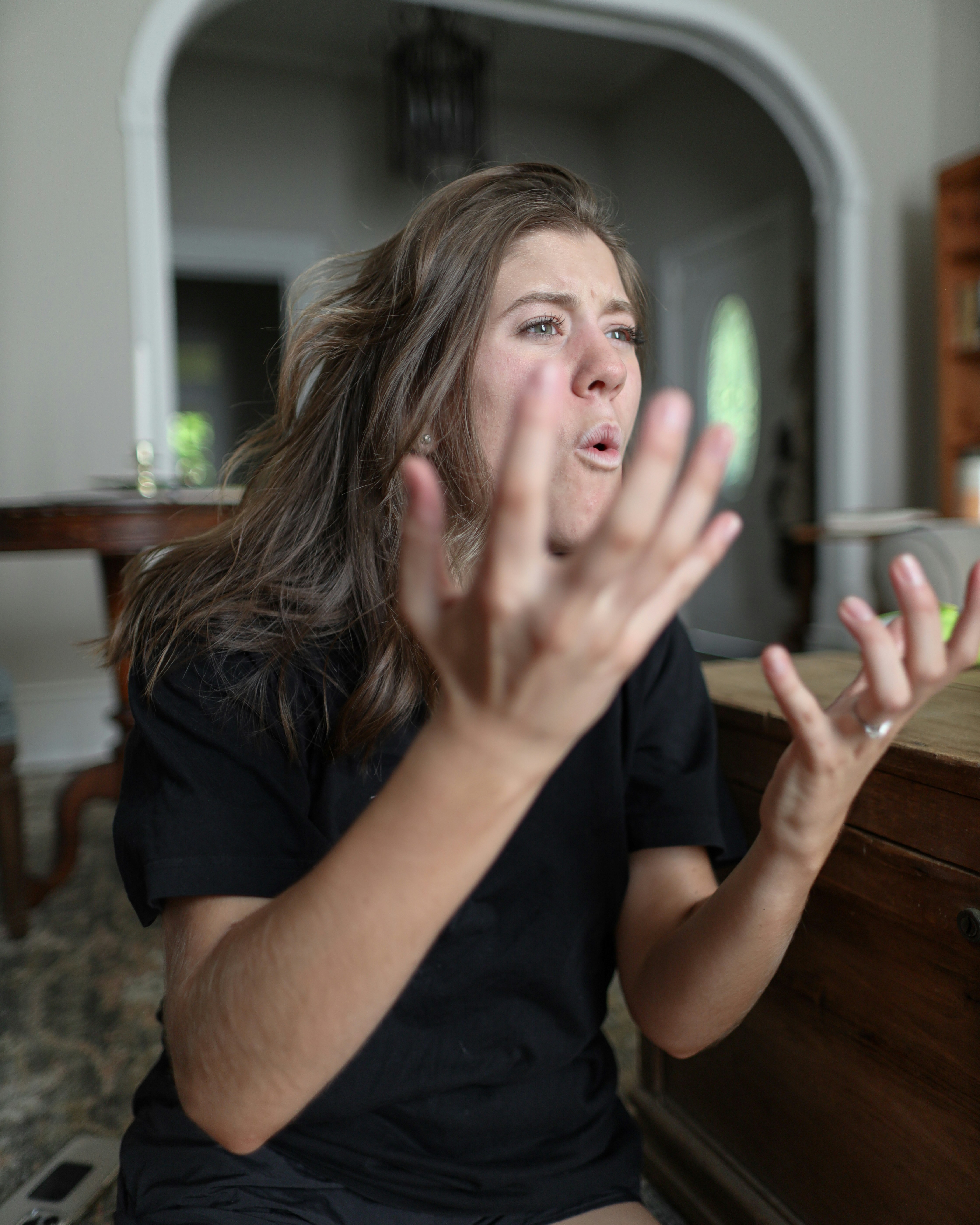 An entitled woman, looking stressed and gesturing with her hands, expresses anger about her sister's wedding ruining her vacation.