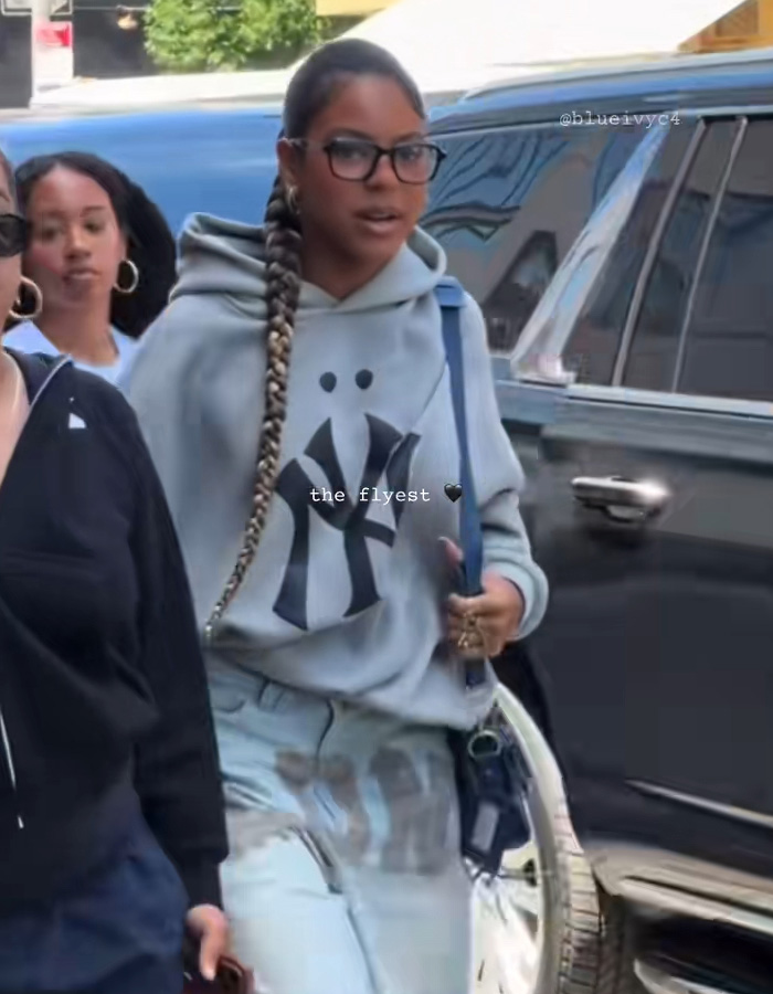 Blue Ivy wearing glasses, a grey hoodie, and a long braid, reflecting Beyonc&eacute;'s parenting style.