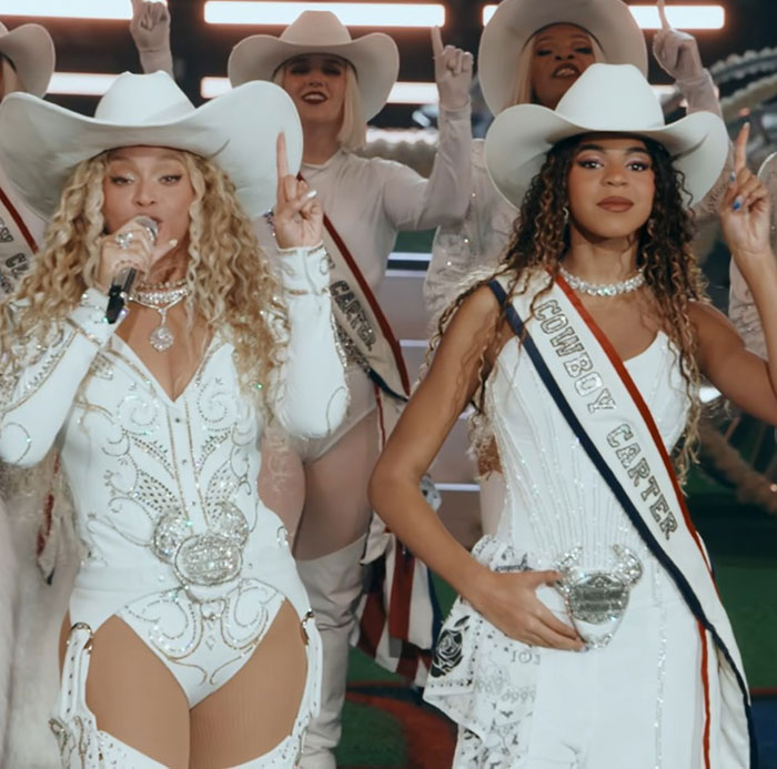 Beyonc&eacute; and Blue Ivy in matching white cowboy outfits performing, showcasing Beyonc&eacute;'s parenting style.