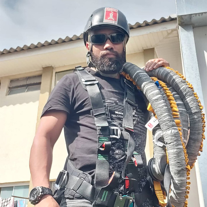 Staff member wearing harness and helmet holding safety ropes Staff member wearing harness and helmet holding safety ropes