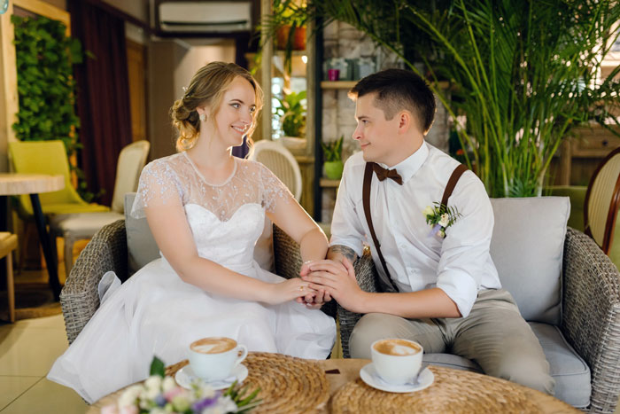 Bride and groom holding hands and smiling in casual wedding setting
