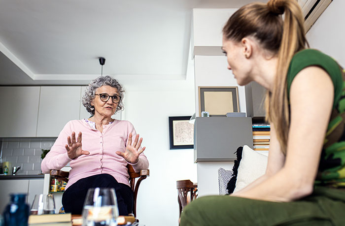 Two women discussing wedding boundary issues in a living room Two women discussing wedding boundary issues in a living room